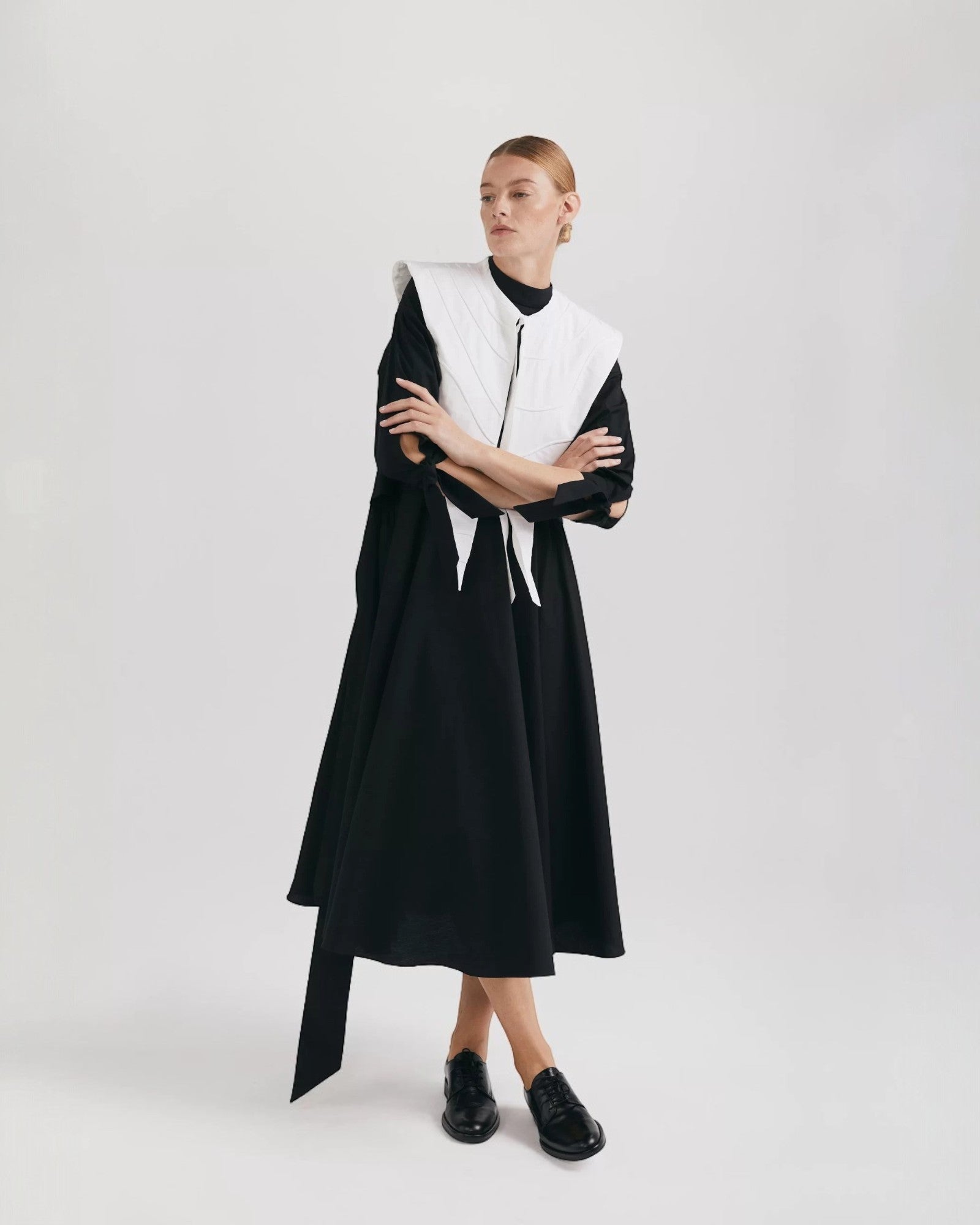 Ipanomi black organic cotton midi dress with flared skirt, mandarin collar, and 3/4 raglan sleeves.