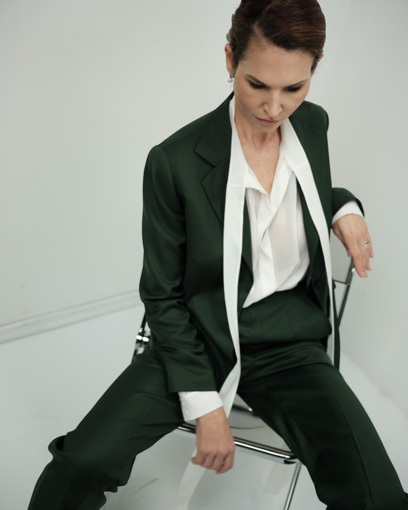 Ipanomi elegant dark green Italian wool trousers with a straight leg and front pleats, paired with a white blouse.