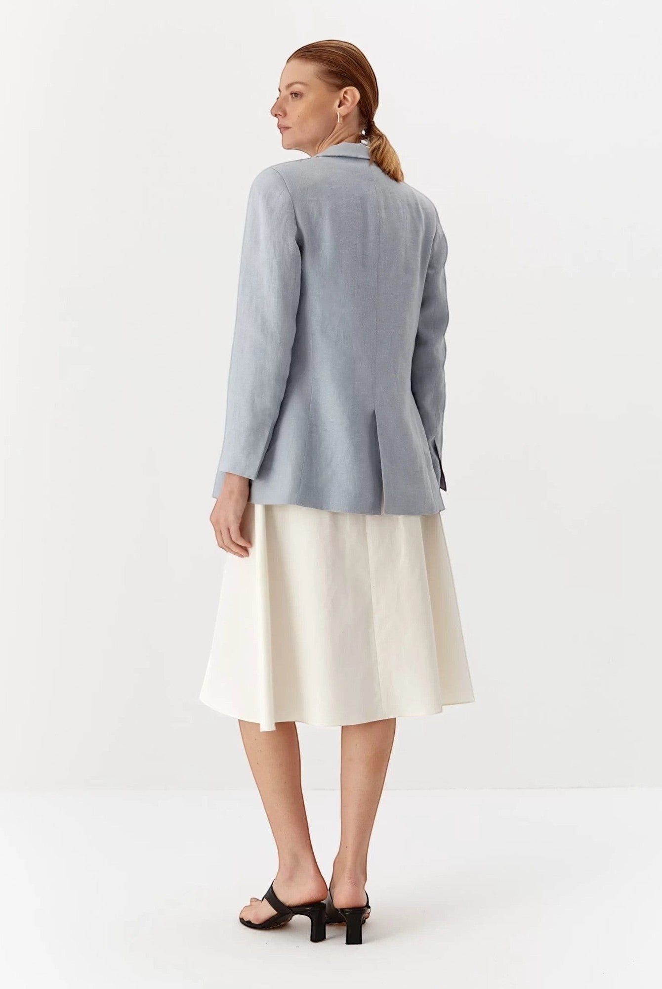 Ipanomi light blue linen fitted blazer with flap pockets and a collared neckline, worn by a model.