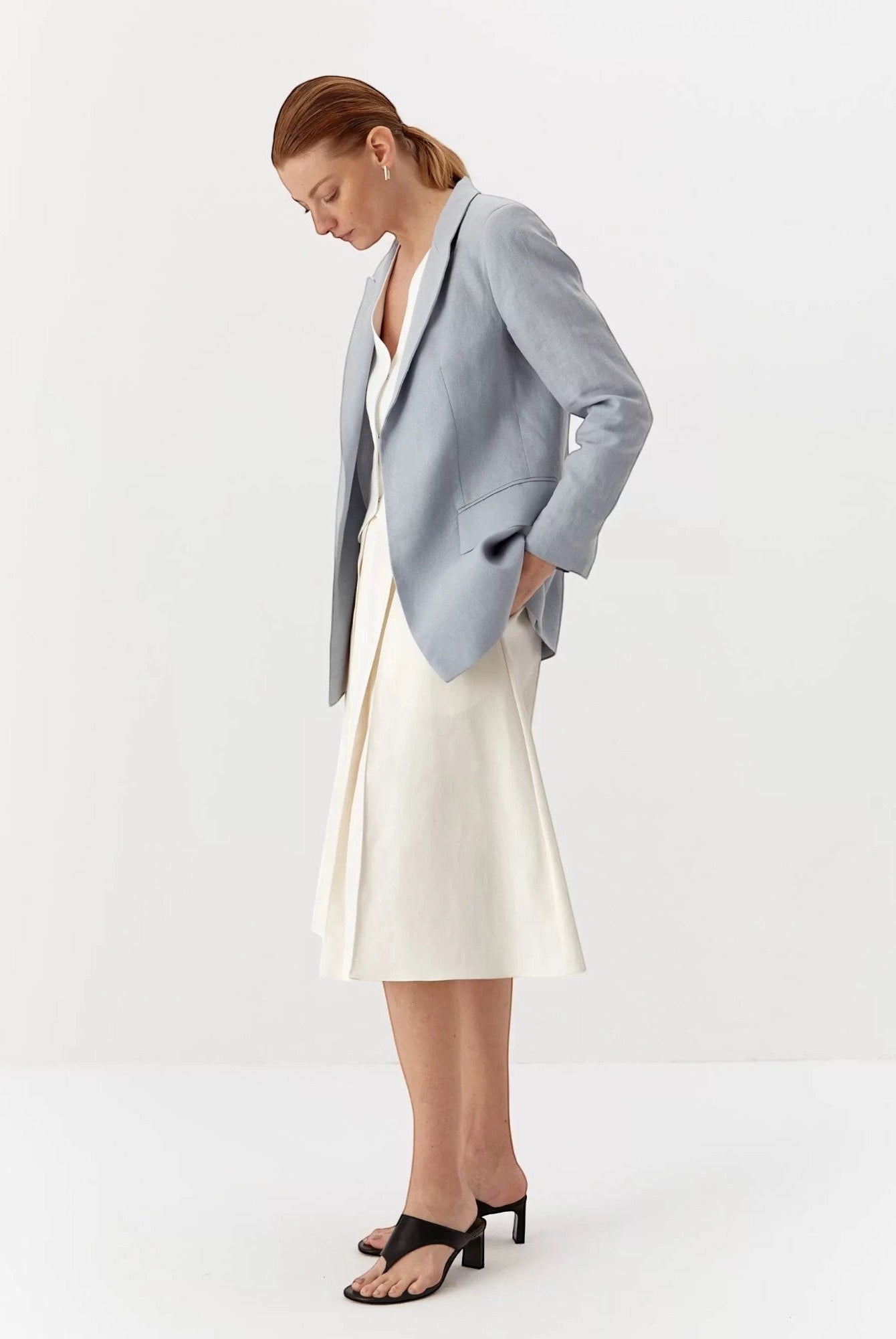 Ipanomi light blue linen blazer with lapel collar, no buttons, and flap pockets. Model is wearing size S.