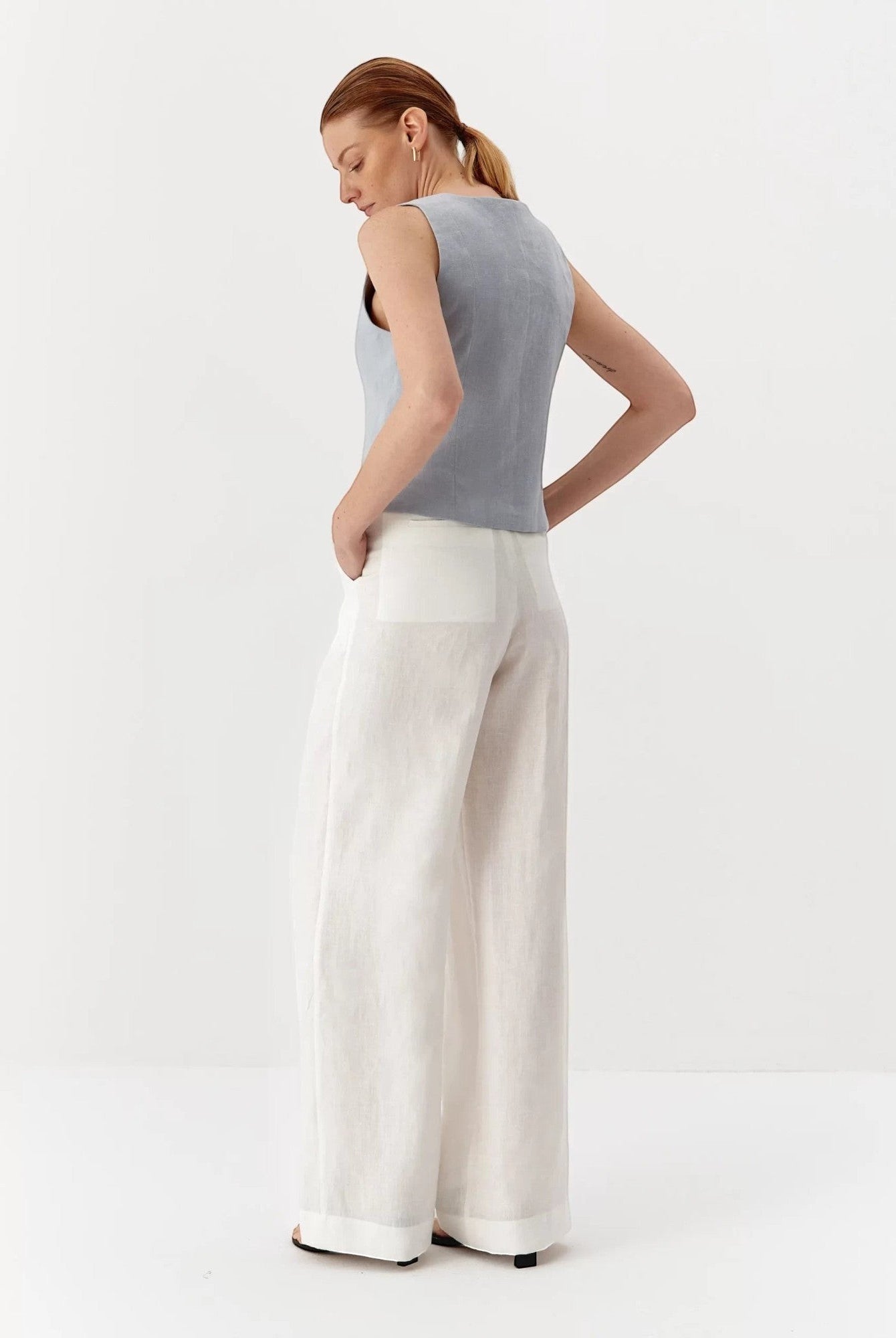 Ipanomi light blue pure linen sleeveless vest with V-neck and contrast buttons. Model wears size S.