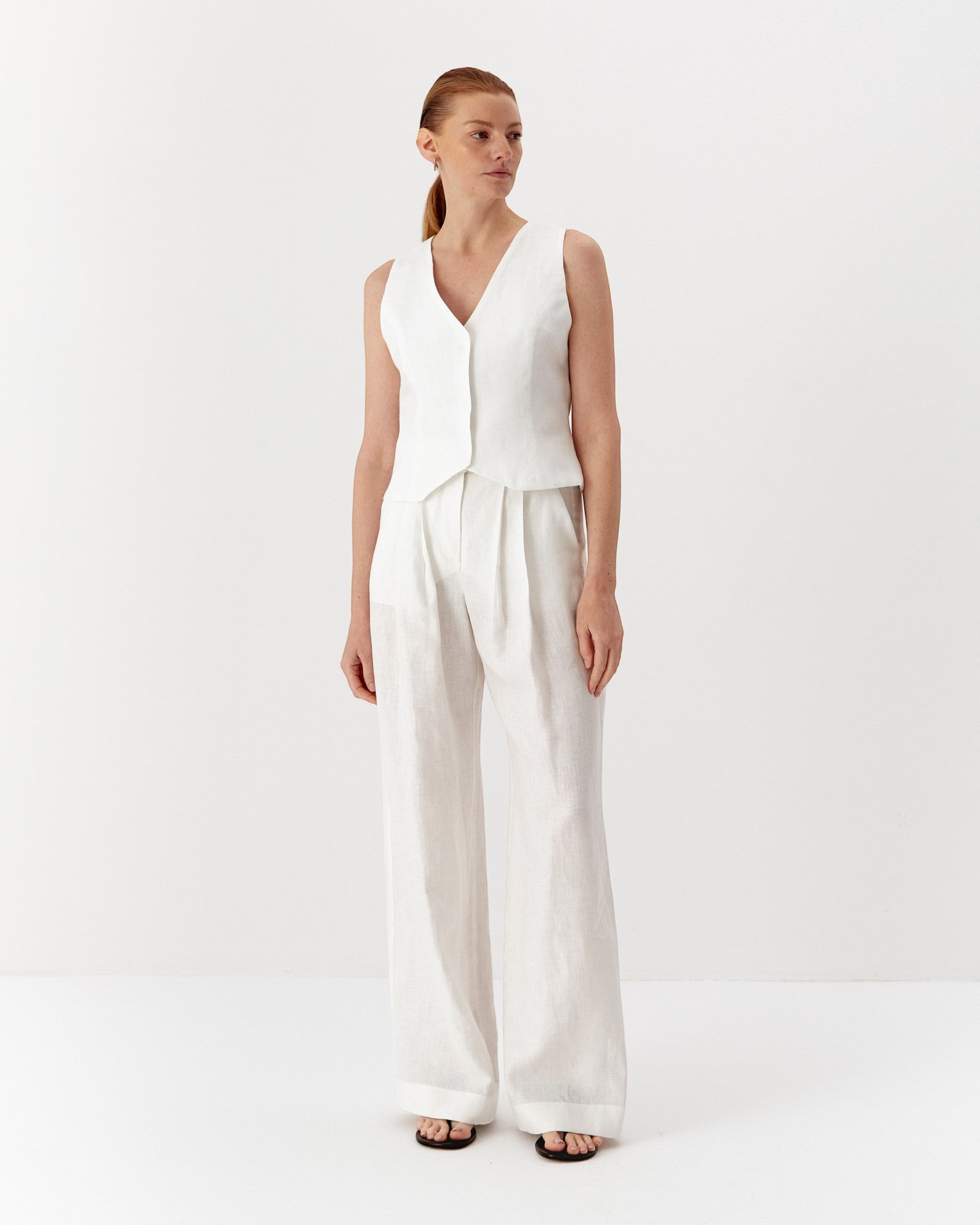 Ipanomi white hemp wide-leg trousers with double pleats and side pockets. Model wearing size S.
