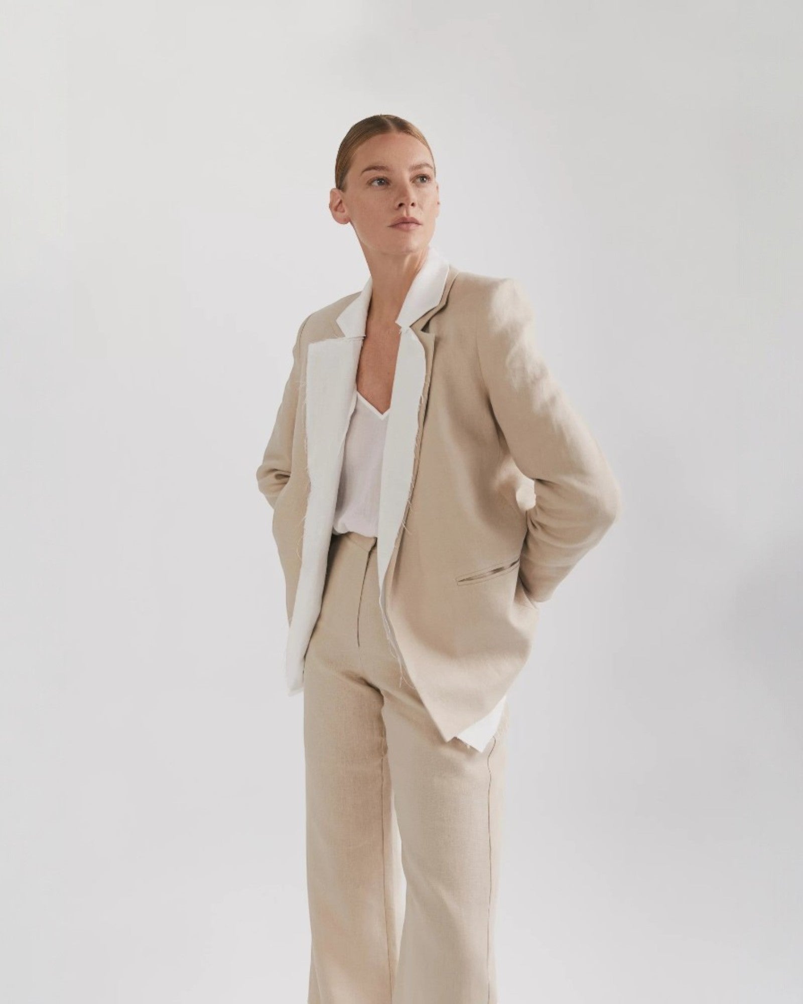 Ipanomi beige linen blazer with white contrast lapels and no buttons. Long sleeves, front pockets, and a feminine cut.