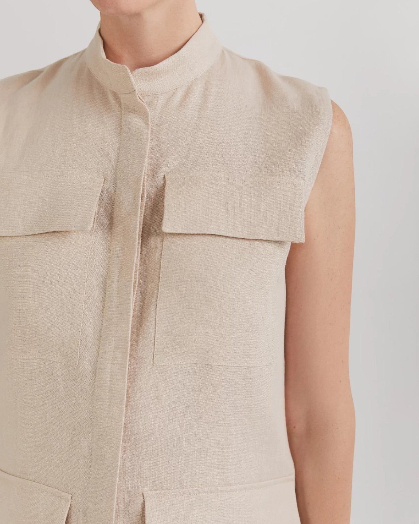 Ipanomi beige linen midi dress with mandarin collar, sleeveless, button-up front, and cargo pockets.