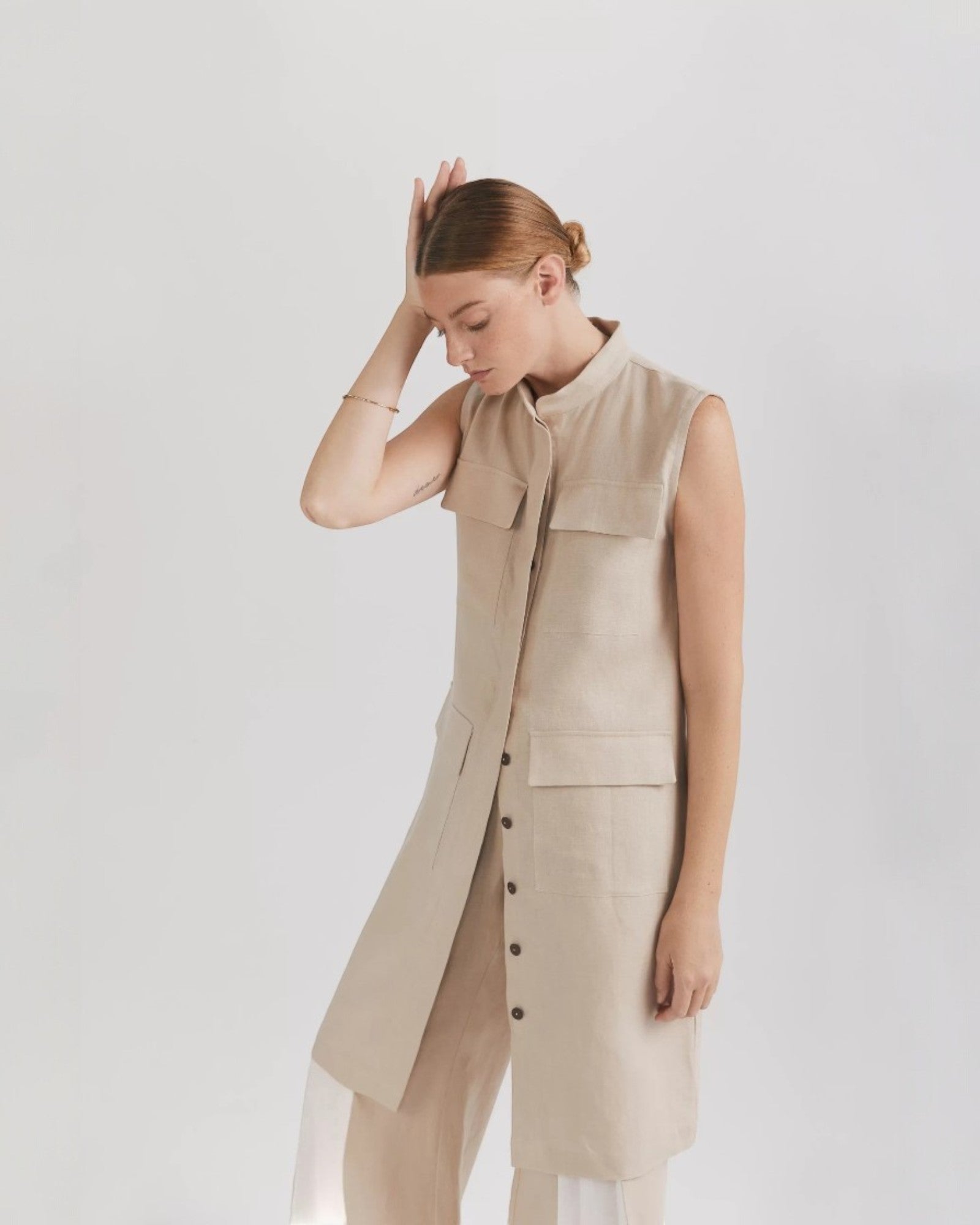 Ipanomi beige linen midi dress with mandarin collar, button front, cargo pockets, and adjustable drawstring. Sleeveless design.