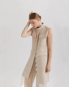 Ipanomi beige linen midi dress with mandarin collar, button front, cargo pockets, and adjustable drawstring. Sleeveless design.