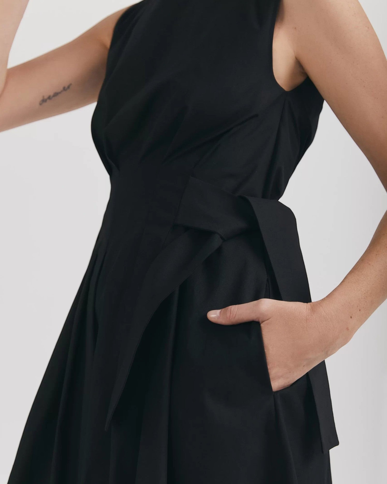 Ipanomi black organic cotton midi dress with sleeveless design, round neck, pleated details, and hidden side pockets.