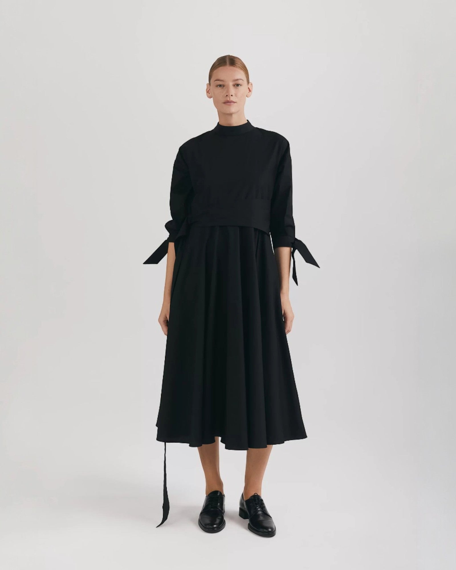 Ipanomi black organic cotton midi dress with mandarin collar, raglan sleeves, and tie details.