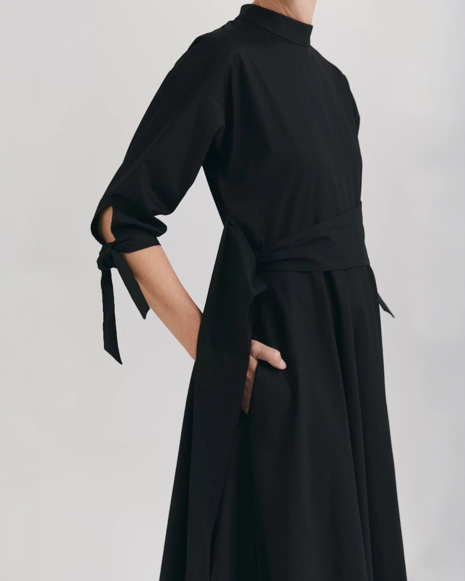 Ipanomi black organic cotton midi dress with mandarin collar, 3/4 raglan sleeves, and tie details.