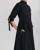 Ipanomi black organic cotton midi dress with mandarin collar, 3/4 raglan sleeves, and tie details.
