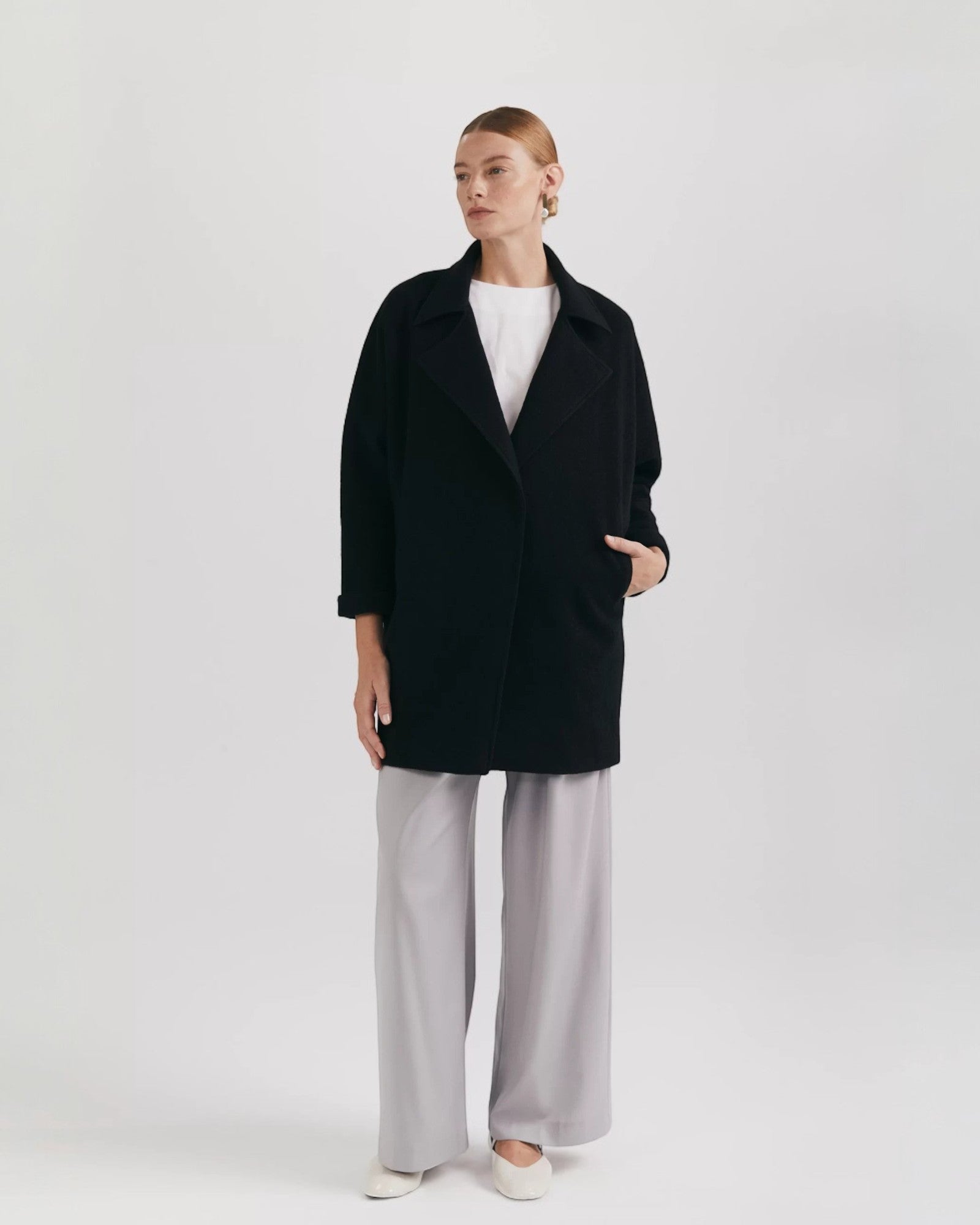 Ipanomi black oversized wool jacket with scarf collar and invisible snap closure.
