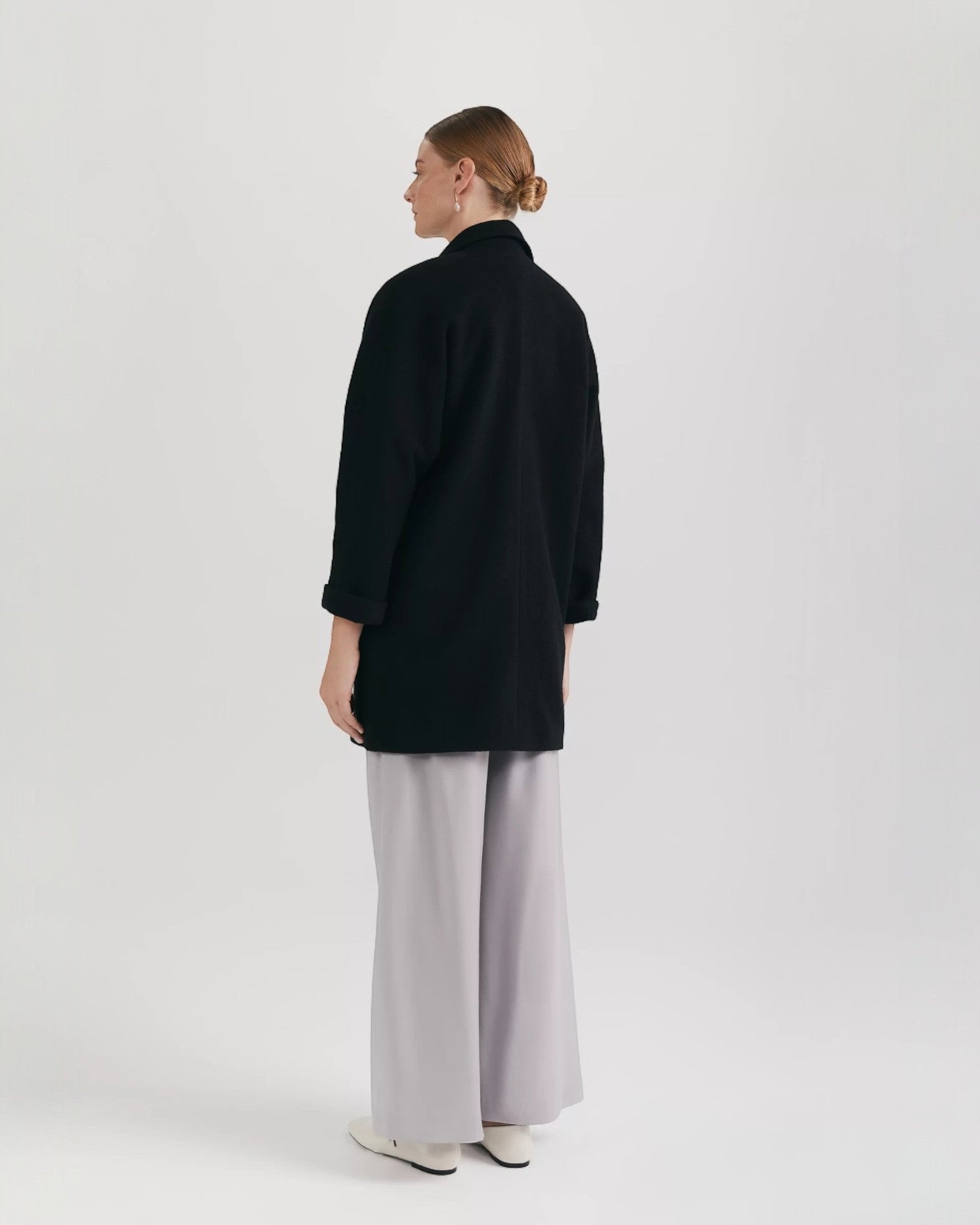 Ipanomi black oversized wool jacket with scarf collar and invisible snap closure.