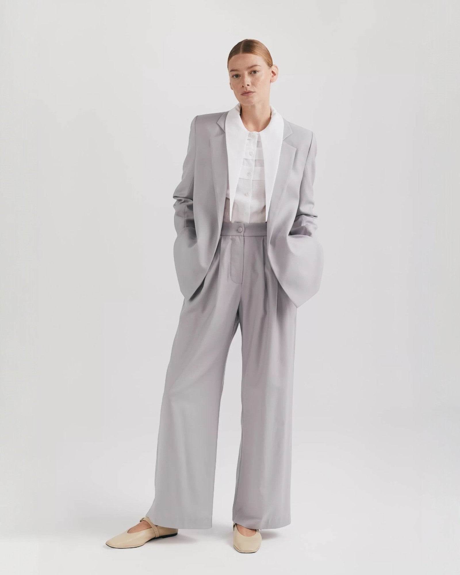 Ipanomi grey premium wool palazzo pants with double pleats, side pockets, and a hidden zipper. Elegant wide-leg trousers.