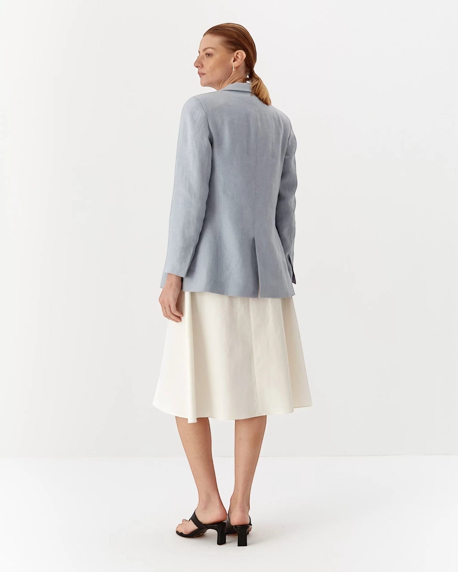 Ipanomi light blue linen fitted blazer with flap pockets and a collared neckline, worn by a model.