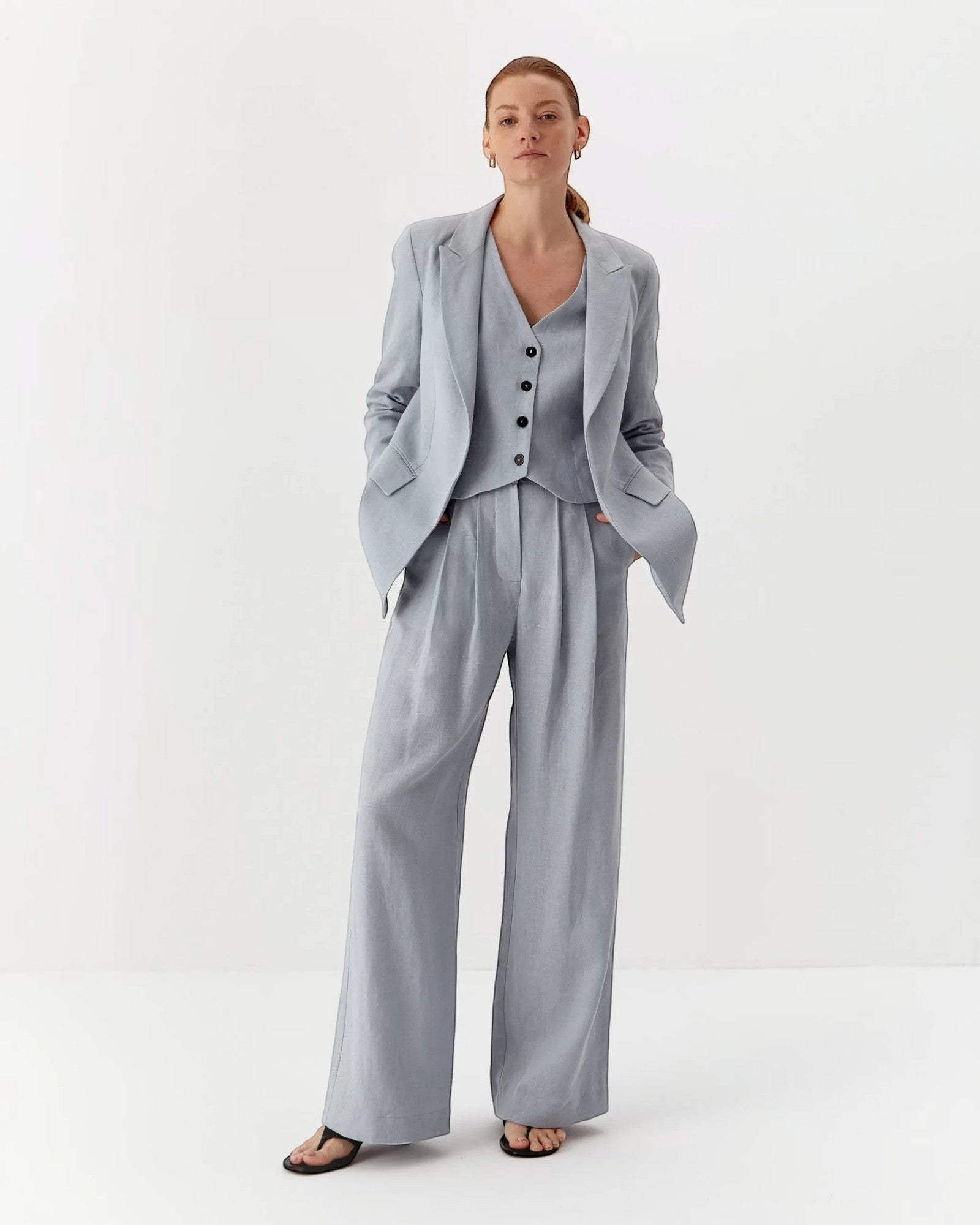Ipanomi light blue pure linen wide-leg trousers with double pleats and high waist. Model wearing size S.