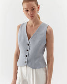 Ipanomi light blue pure linen short vest with V-neck and contrast buttons. Model wears size S.