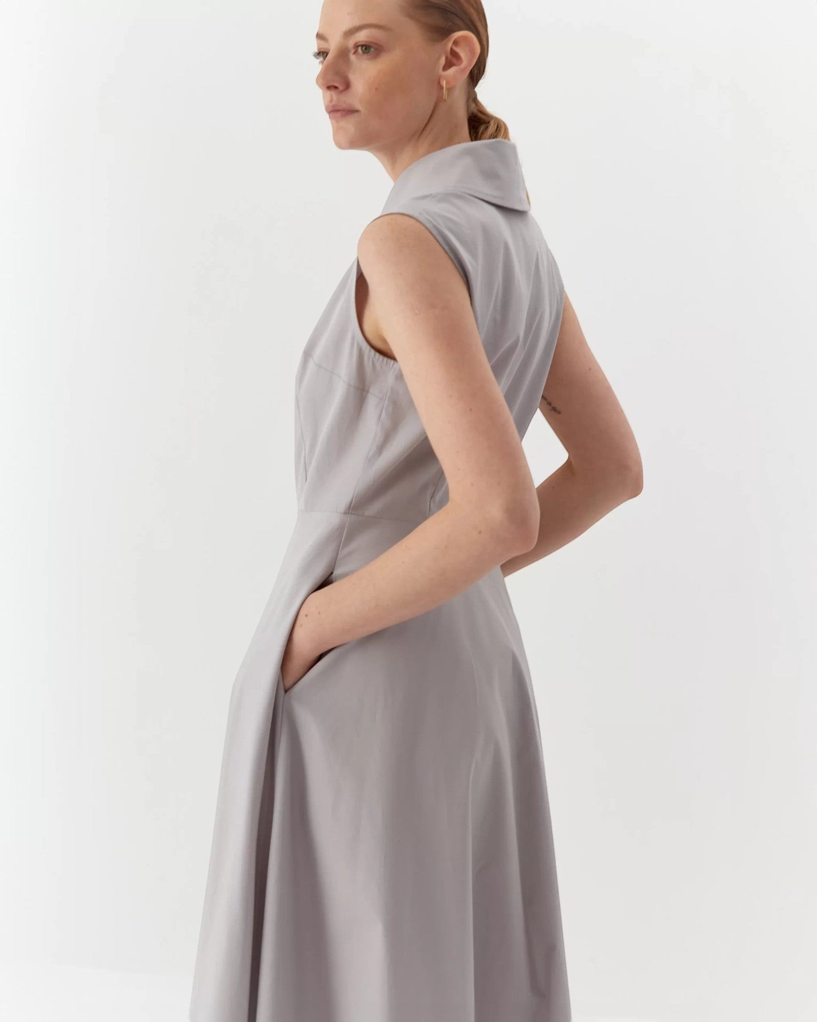 Ipanomi light grey organic cotton maxi dress with collar, buttons, and hidden pockets. Sleeveless A-line silhouette.