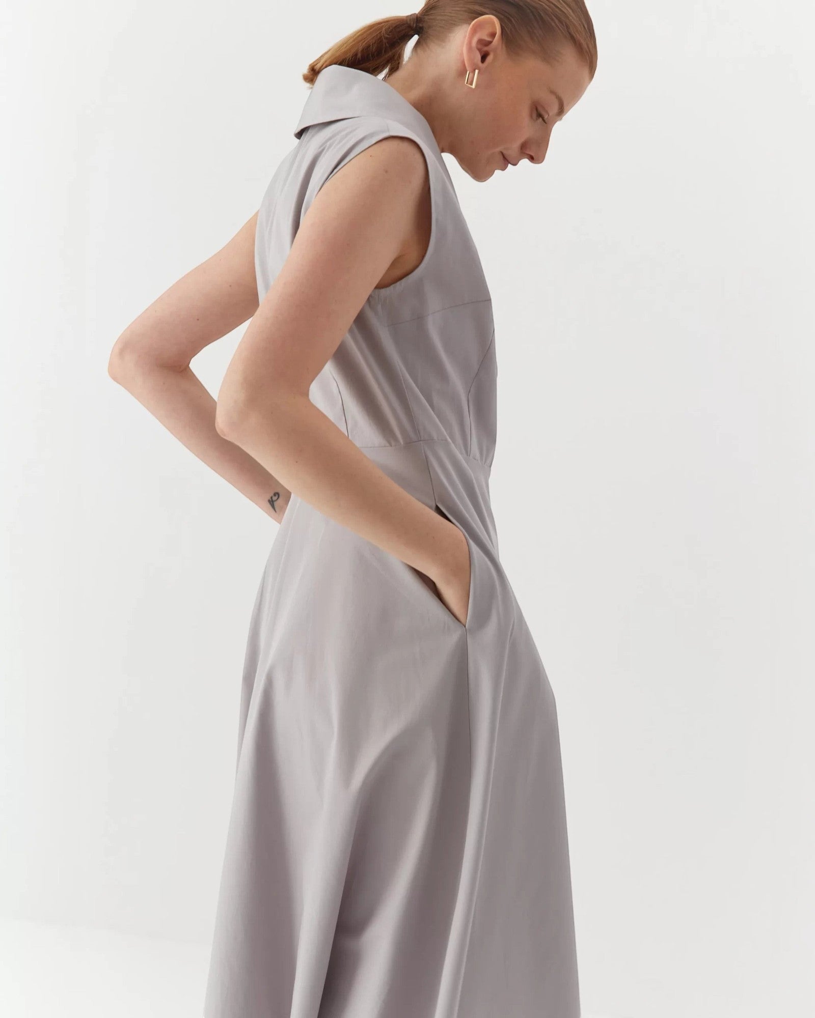 Ipanomi light grey organic cotton maxi dress with collar, button closure, and hidden pockets. Sleeveless A-line silhouette.