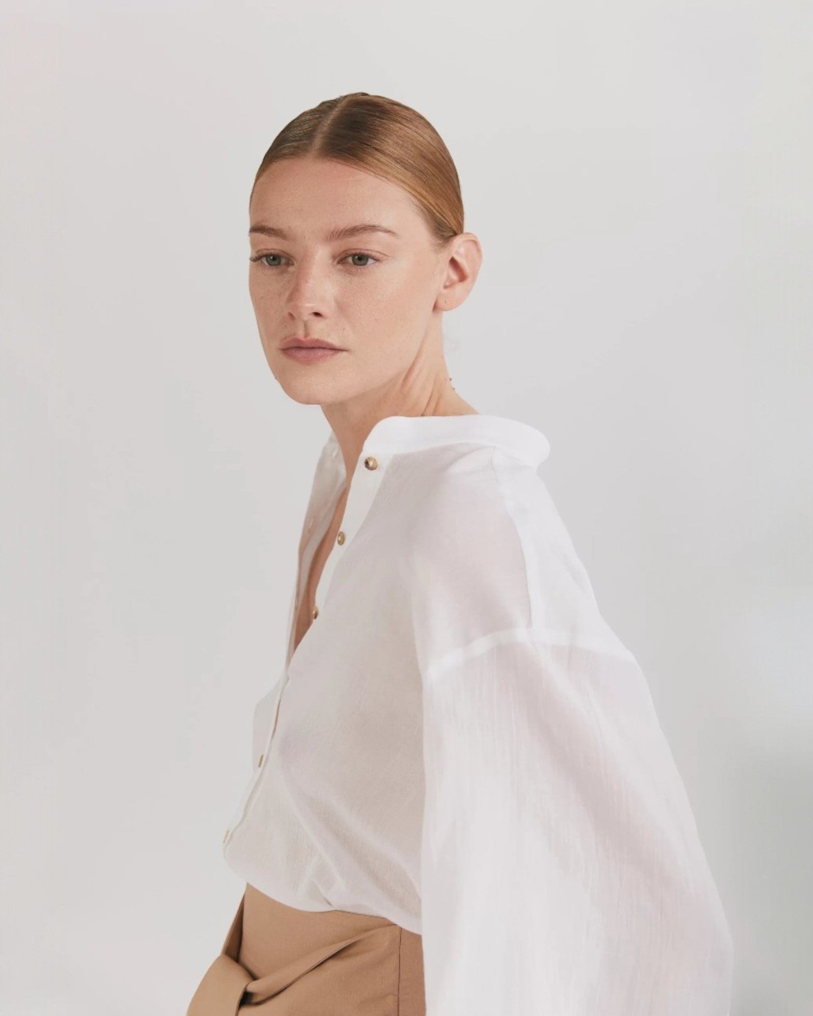 Ipanomi white cotton voile long shirt with balloon sleeves, mandarin collar, and side slits. Button-up front.