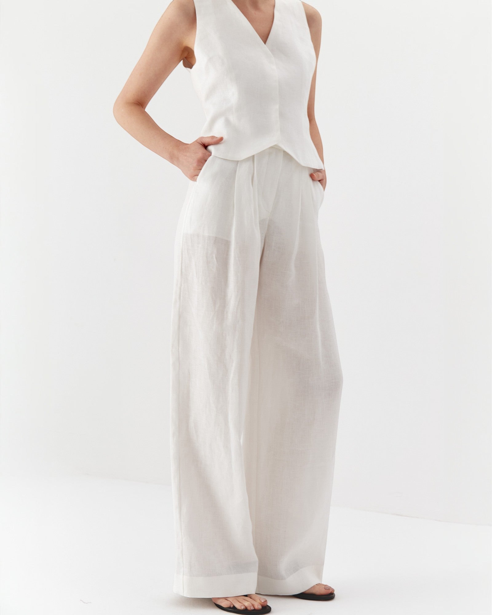 Ipanomi white wide-leg hemp trousers with double pleats and slanted pockets. High-waisted, full-length.