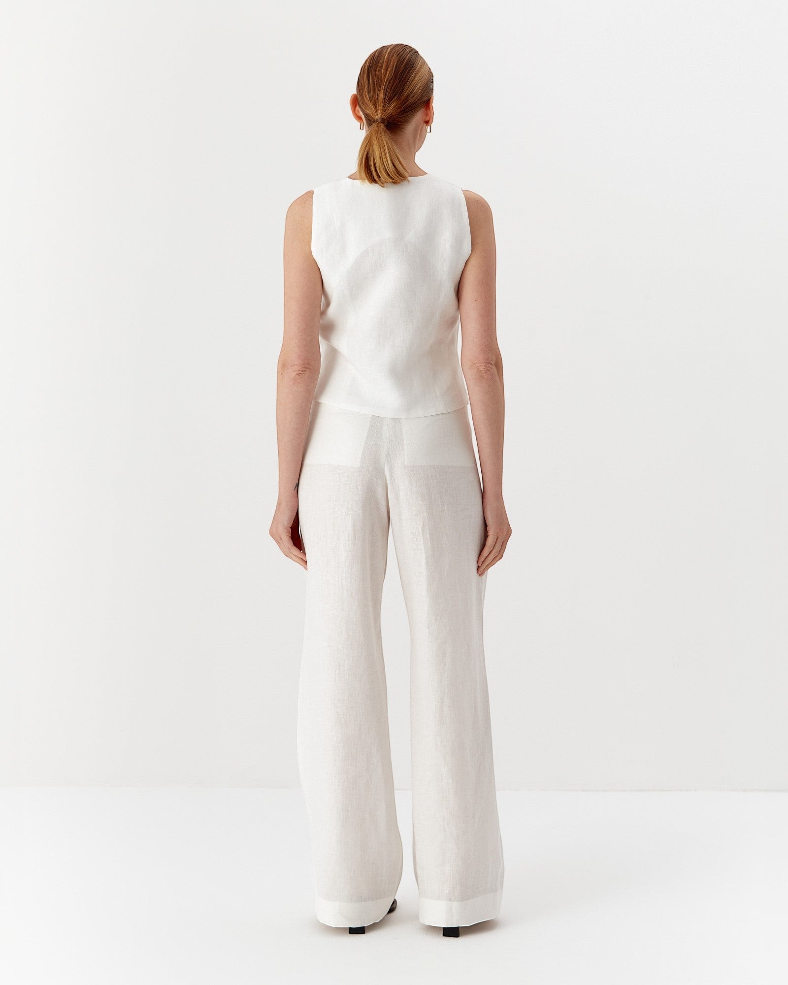 Ipanomi white hemp wide-leg trousers with double pleats and back pockets. Model wears size S.