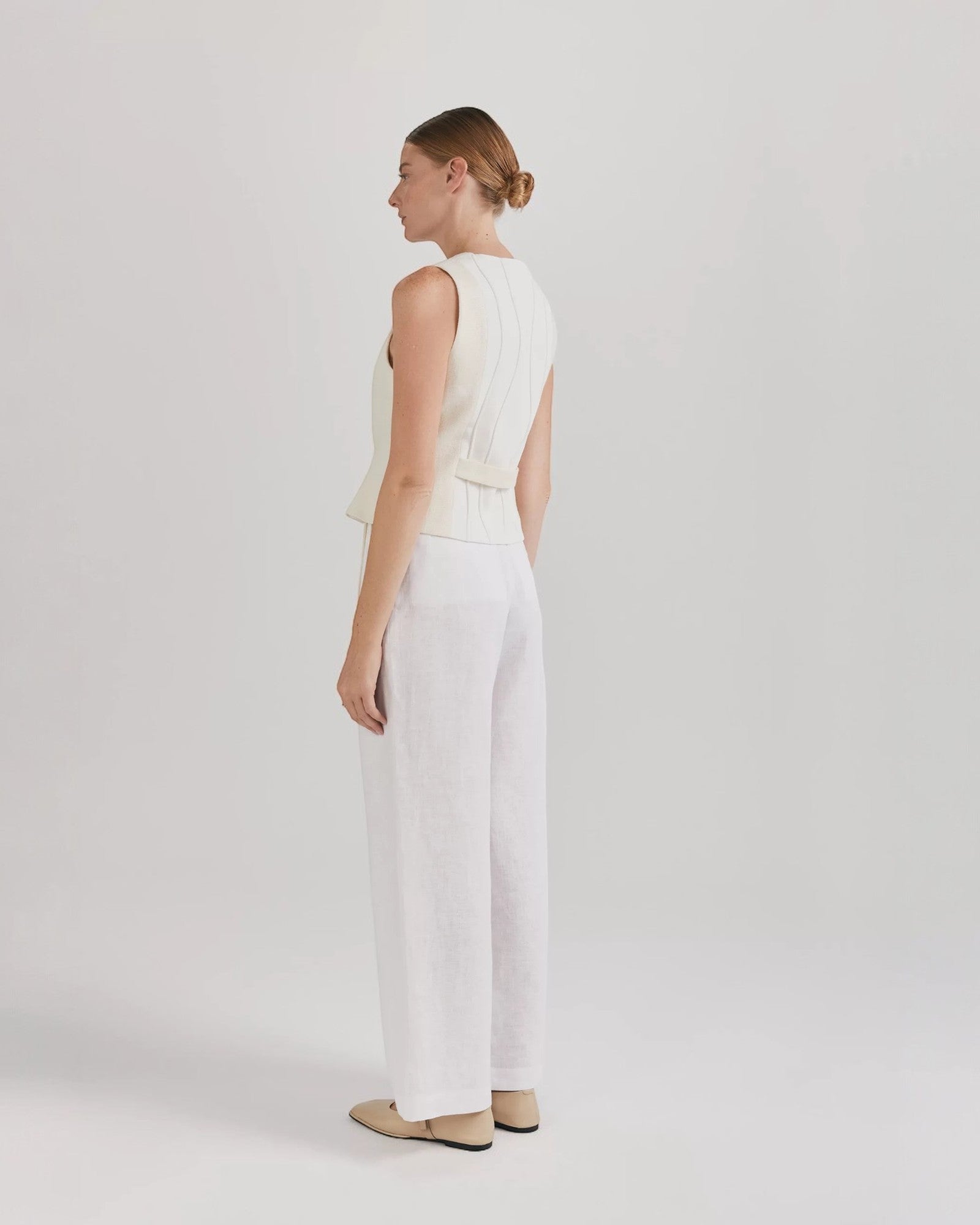 Ipanomi white linen wide-leg trousers with double pleats, side slant pockets, and back pockets.