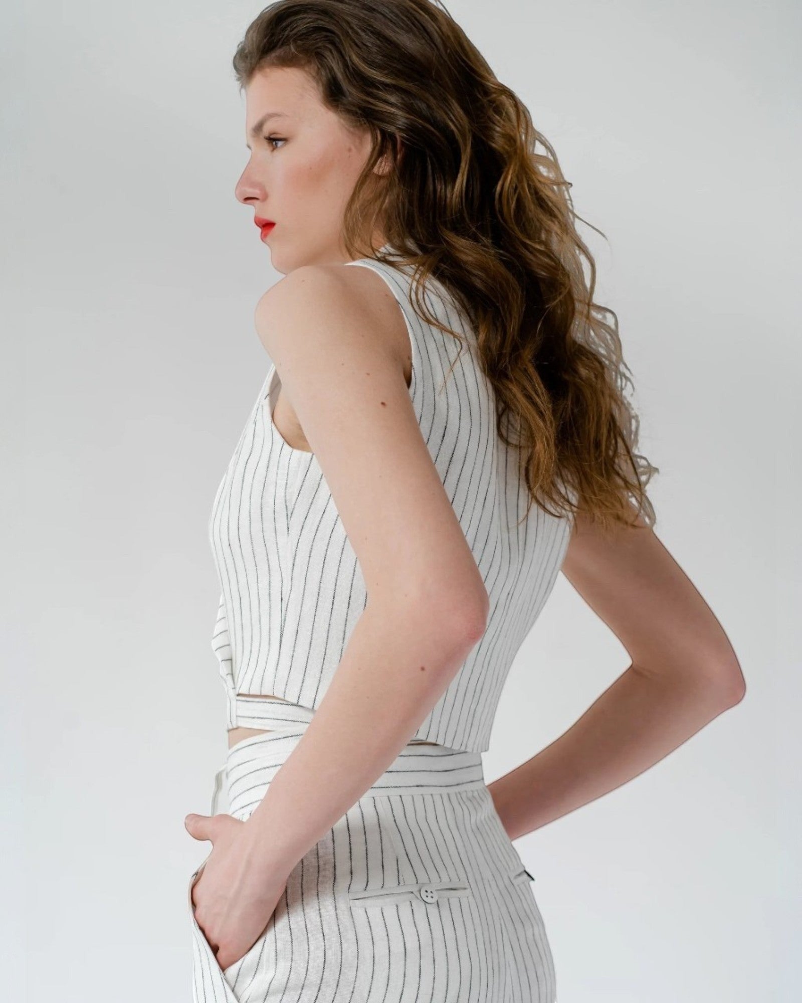 Ipanomi white pinstripe sleeveless cropped vest top with a V-neckline and tie detail.