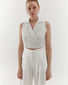 Ipanomi white linen vest with fine black pinstripes, featuring a wrap front and lapel collar.
